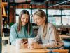 Monteverde apartments Two cheerful smiling women are watching social networks in a coffeshop